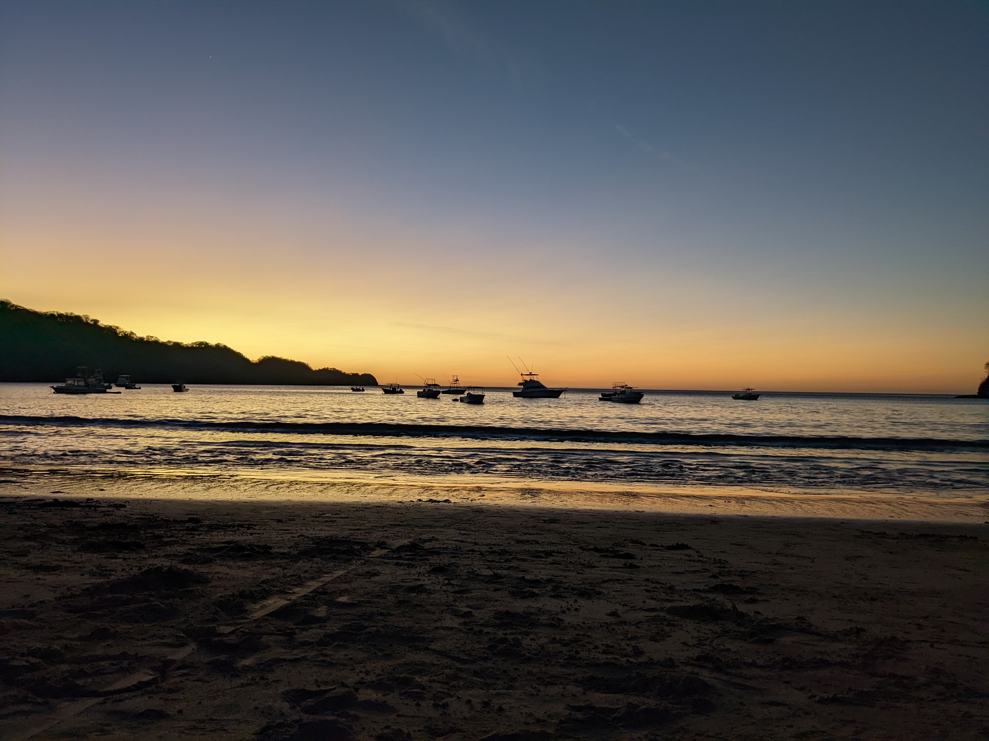 Atardecer en la playa con botes